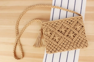 Detail of bohemian handwoven beige cotton bag with diamond patterns and tassel trim
