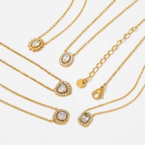 Set of five gold titanium steel necklaces with zircon pendants on a white background