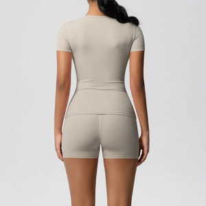 Rear view of a tight beige short-sleeve top and matching high-waist fitness shorts
