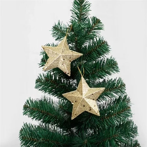 Glittery gold pentagram star ornaments hanging on a green Christmas tree branch