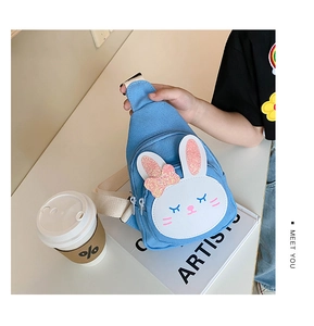 Detail of blue canvas kids chest bag featuring sequin rabbit ears and wide woven strap
