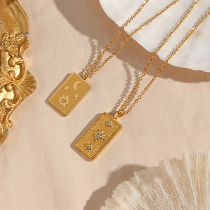 Macro detail of gold tarot card pendants with zircons on elegant cream silk fabric