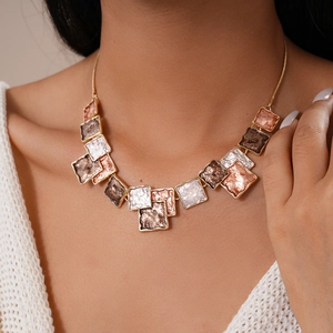 Detail of a layered choker with gold and silver square metal plates on a model's neck