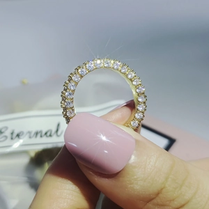 Close-up of gold eternity ring featuring three rows of pavé set white zircon stones