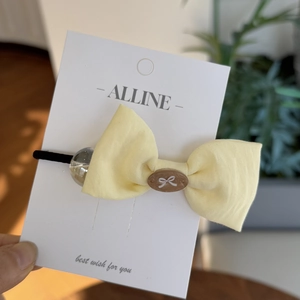 Light yellow linen hair scrunchie with sweet bow tie design and a decorative clear bead