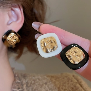 Macro shot of vintage square tortoise acetate stud earrings with hammered gold centers