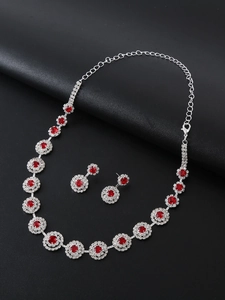 Macro detail of red crystal necklace and earrings set on silver metal base