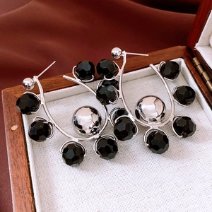 Detail of silver drop earrings with black faceted beads in a vintage wooden jewelry box