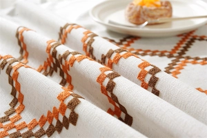 Macro view of textured cotton linen tablecloth with 3D embroidery and elegant drape