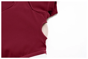 Detail of burgundy yoga top featuring side cutout design and built-in padded bra inserts