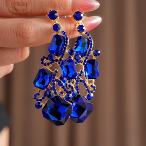 Detail of vintage gold chandelier earrings with large blue square crystals and rhinestones