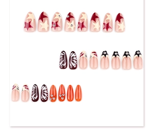 Short almond press-on nails featuring red star patterns, brown swirls, and orange rhinestones