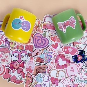 Close-up of holographic heart stickers with pink laser finish on mugs and notebooks