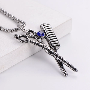 Vintage stainless steel barber necklace with scissors, comb and blue rhinestone detail