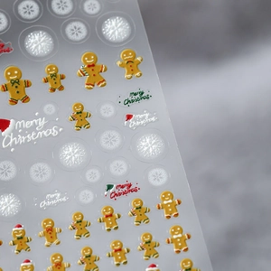 5D Christmas nail art stickers with gingerbread men and snowflakes on a sheet