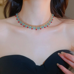 Detail of beaded ethnic choker with turquoise and red beads on gold finish chain