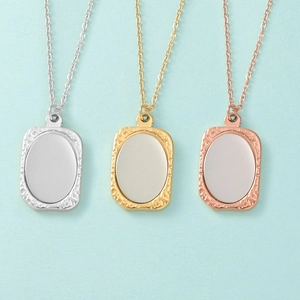 Detail van zilveren gouden en roségouden getextureerde rechthoekige hangers aan kettingen