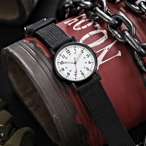 Detail of military style watch with black nylon strap and dual 24-hour scale dial
