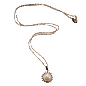 Elegant gold necklace featuring a freshwater pearl pendant with a halo of zircon stones