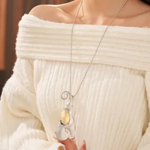 Brushed stainless steel elephant pendant necklace on a chunky knit sweater