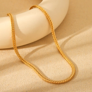Detailed view of 18K gold plated titanium steel braided chain necklace on a display