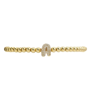 Golden beaded bracelet with a sparkling cubic zirconia bubble letter A pendant on white background
