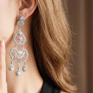Vintage bohemian silver teardrop earrings with blue and pink rhinestones on a model