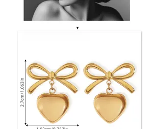Detail view of heart and bow earrings showing dimensions 2.7cm by 1.92cm in gold finish
