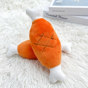 Detailed view of plush drumstick dog toys on a white soft rug with crisp fabric textures