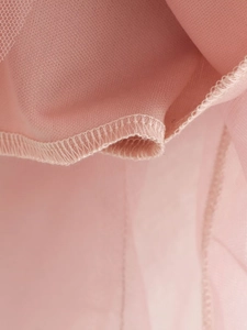 Macro view of pink tiered mesh skirt showing high-quality stitching and fabric texture