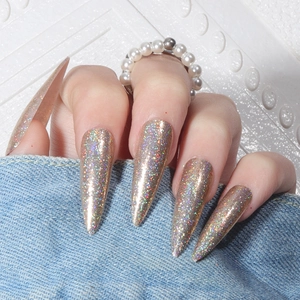 Close-up of long stiletto press-on nails with holographic gold glitter finish