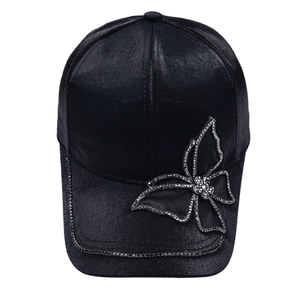 Close-up of black satin baseball cap with rhinestone butterfly and crystal edge trim