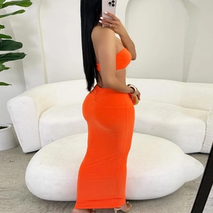 Detail of a bright orange two-piece bodycon knit set with tube top and long maxi skirt