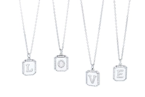 Silver letter pendants L O V E necklaces with cubic zirconia on white background