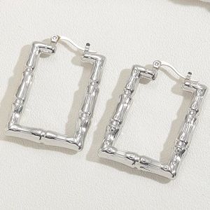 Detailed macro view of silver stainless steel rectangular earrings with bamboo texture