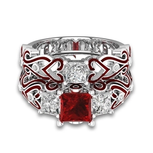Detail van rode vierkante zirkoonring met hartpatroon zilveren band en zijstenen wit