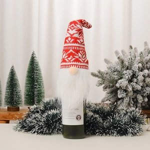 Détail d'un couvre-bouteille de vin gnome de Noël avec bonnet rouge tricoté et longue barbe