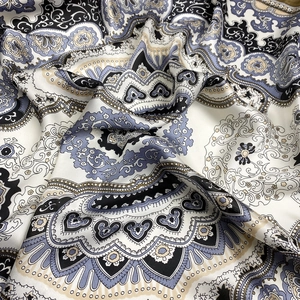 Gros plan sur un tissu en satin de soie avec motif paisley et éclat métallique doux