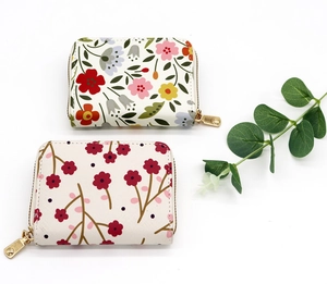 Detailed close-up of floral accordion wallets with zip closure and textured PU leather