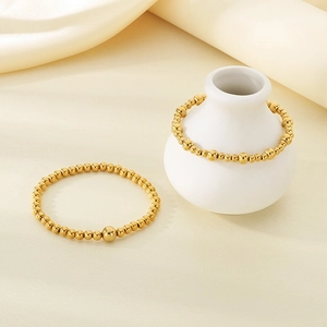 Elegant 18K gold-plated stainless steel bead bracelets set on a beige silk background