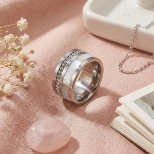 Anello di conchiglia alla moda con zirconi su una moderna fascia larga in acciaio
