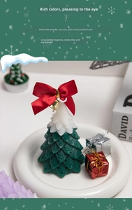 Detailed macro shot of Christmas tree scented candle with red bow and gold bell decor