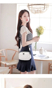 Quilted white crossbody bag with striped wide strap worn by a model in casual style