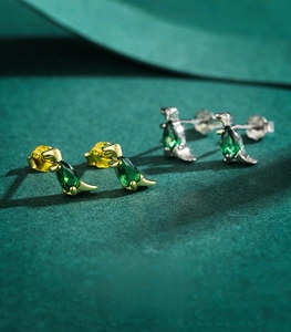 Detailed shot of S925 sterling silver dinosaur earrings with green crystal inlay