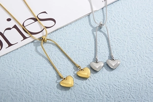 Detailed view of gold and silver Y-shaped snake chains with 3D heart-shaped pendants