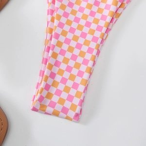Detailed close-up of pink and orange checkered fabric pattern on bikini swimwear