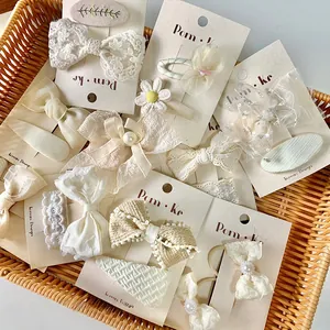Detail view of Korean lace bow hair clips set with pearls and embroidery on a card
