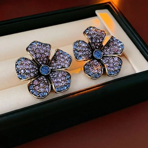 Vintage flower earrings with purple and blue crystals in a luxury jewelry box