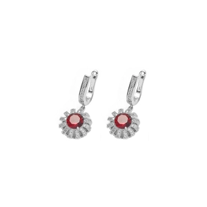 Detailed macro view of U-shaped silver earring with round red gemstone and clear zircon