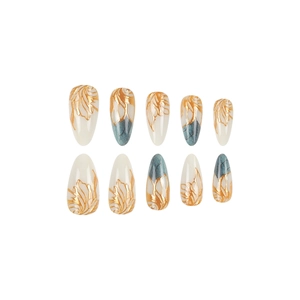 Almond-shaped white press-on nails with golden floral relief and blue marble texture